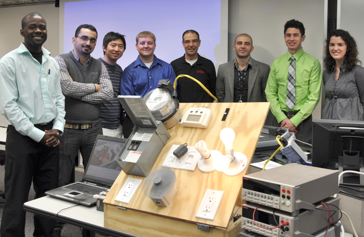 Photo of members of Nebraska Engineering's I-SAVE team stand with their prototype energy monitoring device.