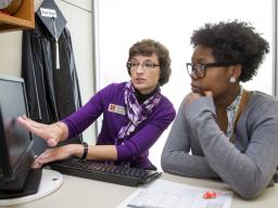 An advisor helps a student plan to register for spring classes.