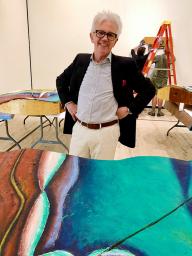 Wally Mason with the painting "Wishing for the Farm," shown in three parts during installation.