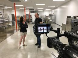 Brandee Weber (left), with fellow UNL alum Christopher Elbow, discuss aspects of Elbow’s chocolate making process at his new production facility in Kansas City, Missouri. Elbow is one of many chocolatiers featured in Weber’s upcoming documentary. (Photo/C