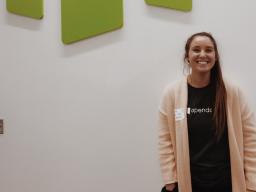 CoJMC senior Paige Stanard smiles in front of the Opendorse logo on her first day as an intern at the office headquarters in Lincoln.