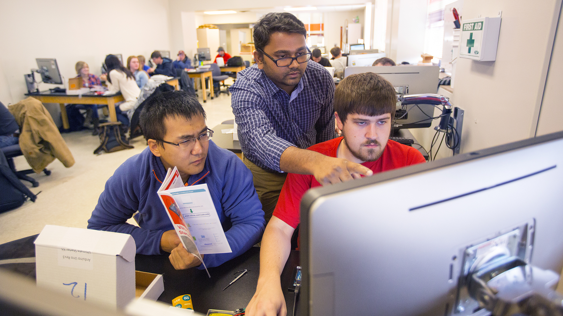 Nebraska researcher Santosh Pitla (center) assists students with a sensor-building project.