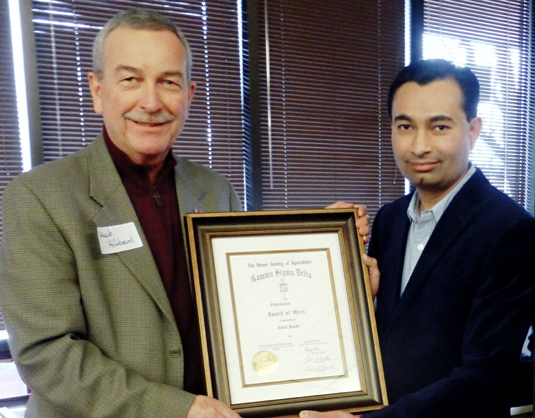 Chuck Hibberd presents The Honor Society of Agriculture Gamma Sigma Delta Extension Award of Merit to Amit Jhala Jan. 27.