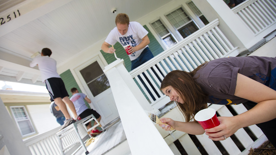 Kate Christensen and Theron Christensen paint porch columns at a house on B Street as part of a citywide Paint-A-Thon Aug. 20, 2016. |  Craig Chandler, University Communication