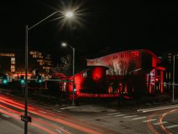 The Van Brunt Visitors Center on City Campus is illuminated in red light. PC: Justin Mohling, University Communications.