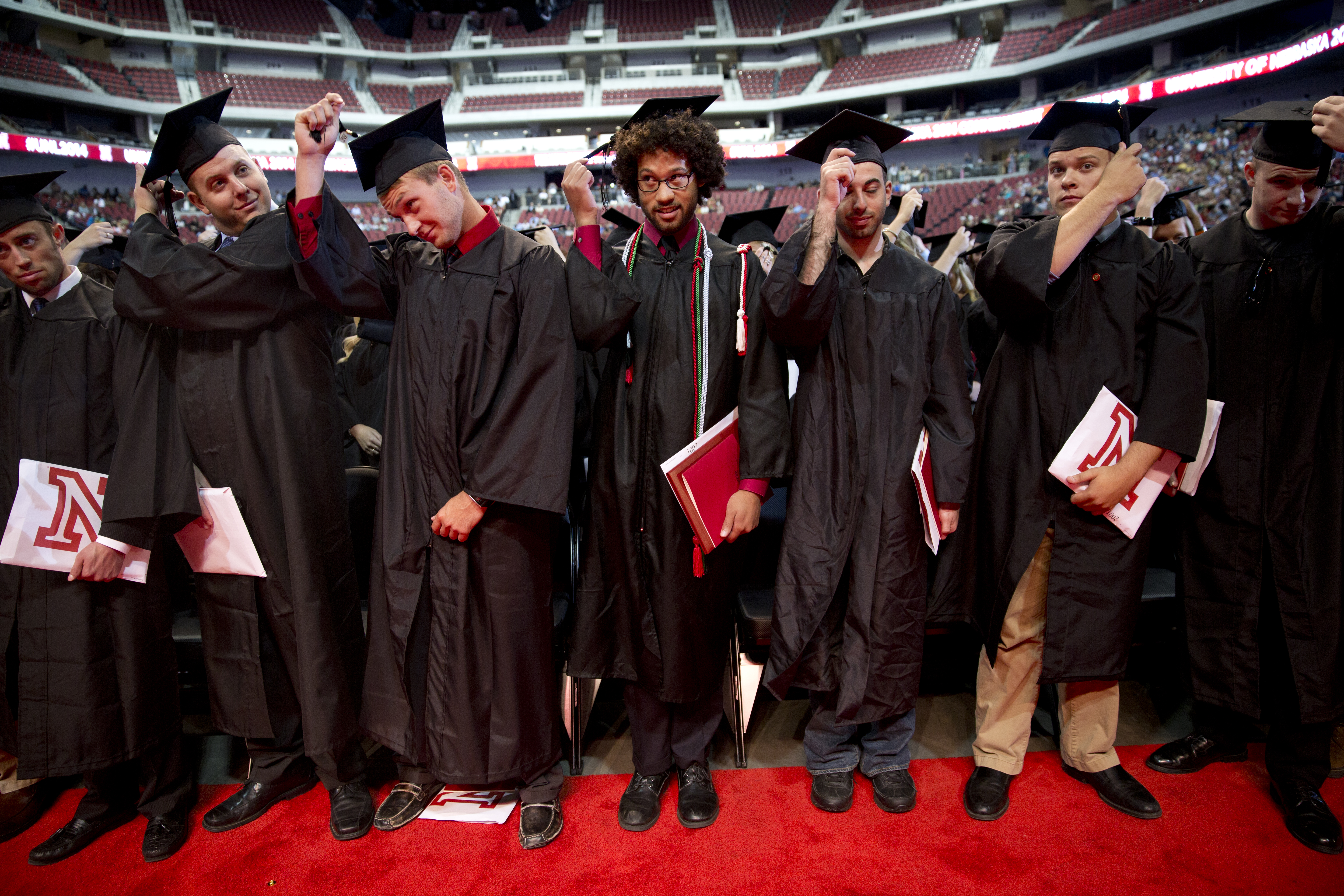 Students turn their tassels to signify their official graduation during the All-University Commencement at Pinnacle Bank Arena on August 16, 2014. Photo by Morgan Spiehs for University Communications Photography.