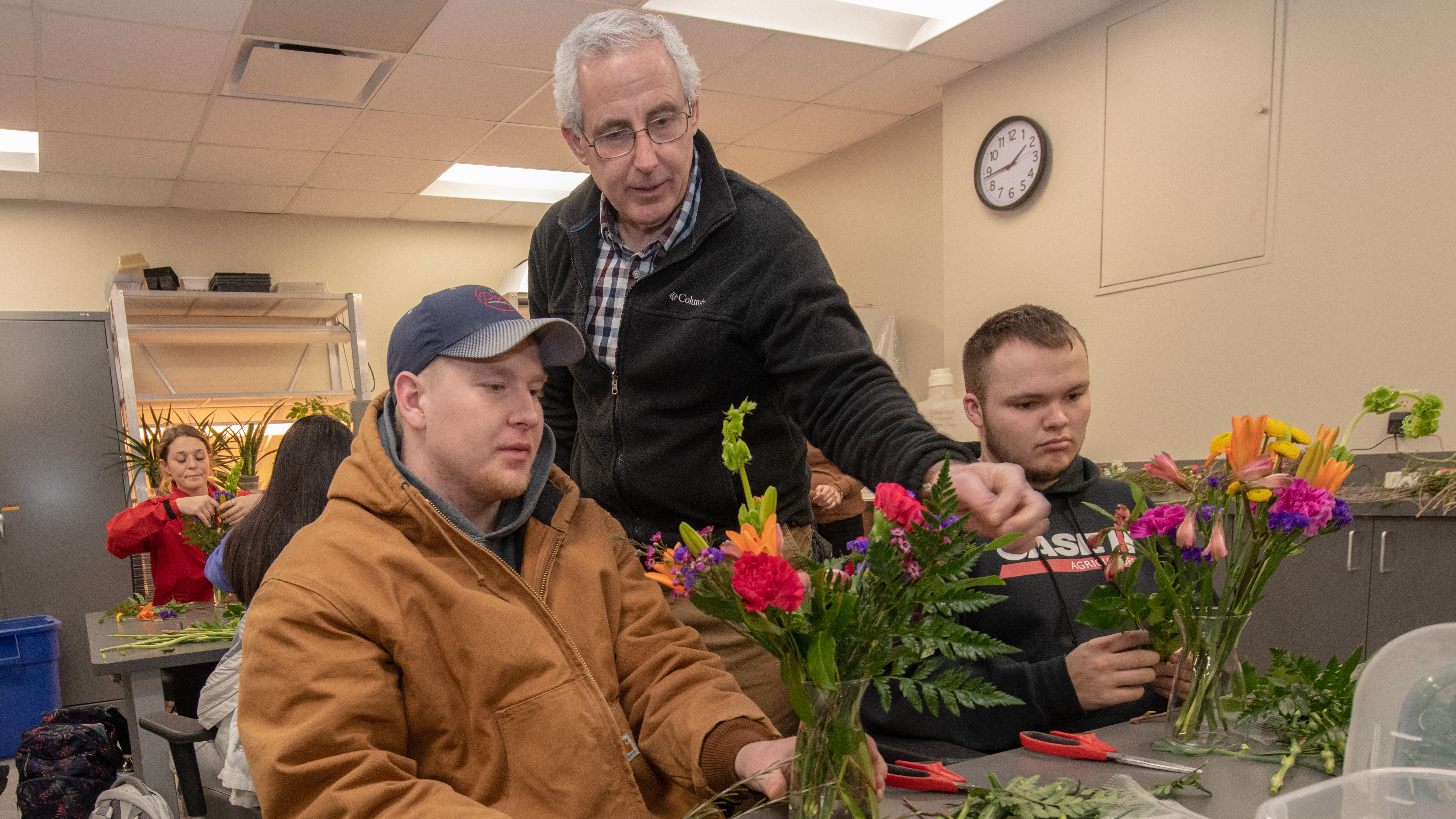 Stacy Adams (center), associate professor of practice in agronomy and horticulture, helps two students create their arrangements in Floral Design class.  Greg Nathan | University Communication