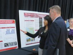 Chancellor Ronnie Green speaks with a student about her research at the 2018 Spring Research Fair.