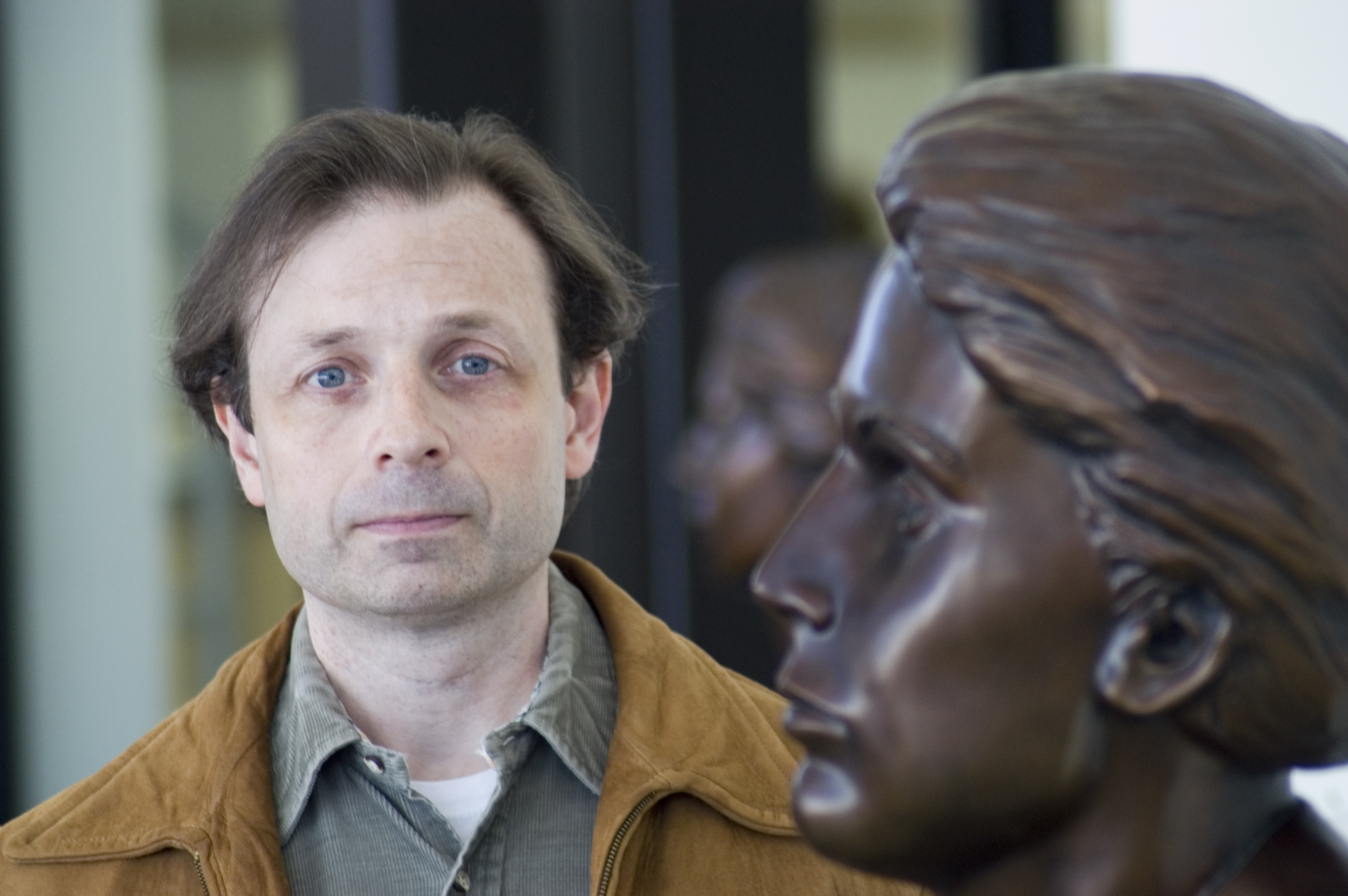 John Sorensen stands next to the bust of Grace Abbott in the entryway of Grand Island's Edith Abbott Memorial Library. 