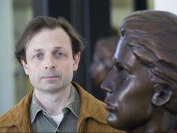 John Sorensen stands next to the bust of Grace Abbott in the entryway of Grand Island's Edith Abbott Memorial Library. 