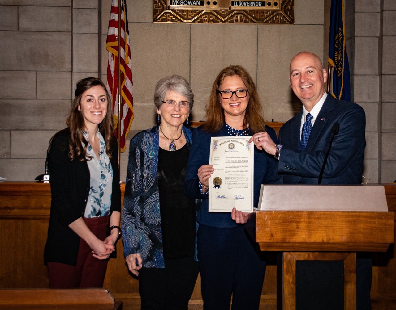 Nicole Vencil (Far Left) and Jean Ann Fisher (Right holding the certificate) stand with Gov. Ricketts as March is proclaimed National Nutrition Month