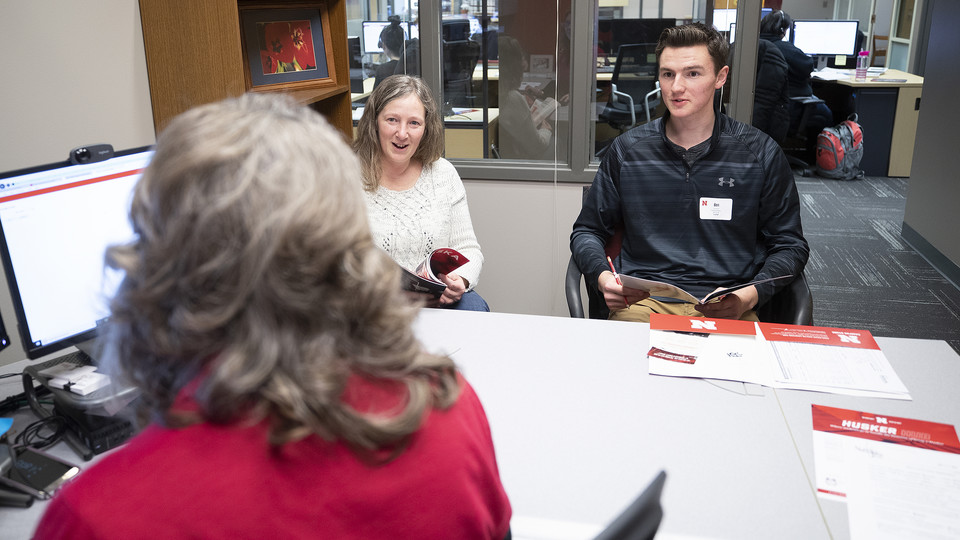 Anna Plank, assistant director of Husker Hub, talks with student Ben Houck and his mother, Cheryl, in the temporary home for Husker Hub. 