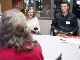 Anna Plank, assistant director of Husker Hub, talks with student Ben Houck and his mother, Cheryl, in the temporary home for Husker Hub. The new one-stop shop offers integrated services, including the offices of Scholarships and Financial Aid, University 