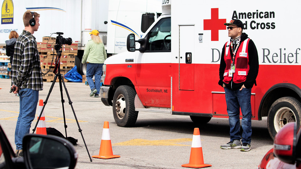Journalism student Kenneth Ferriera interviews Red Cross Disaster Services volunteer Joel Olavarrio outside a shelter in Fremont. 