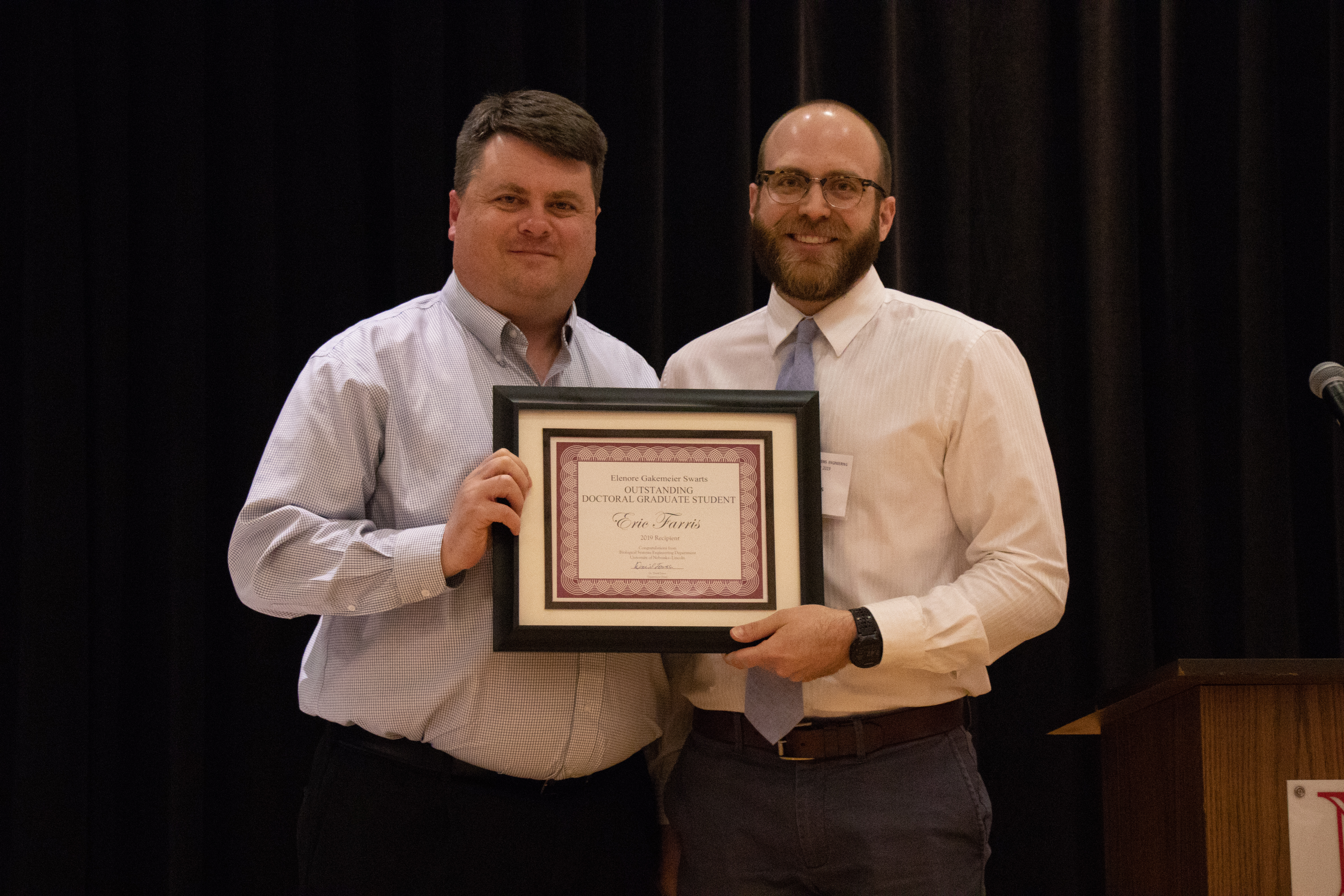 Mark Wilkins (left) presents the Elenore Gakemeier Swarts Outstanding Doctoral Graduate Student Award to Eric Farris (right)