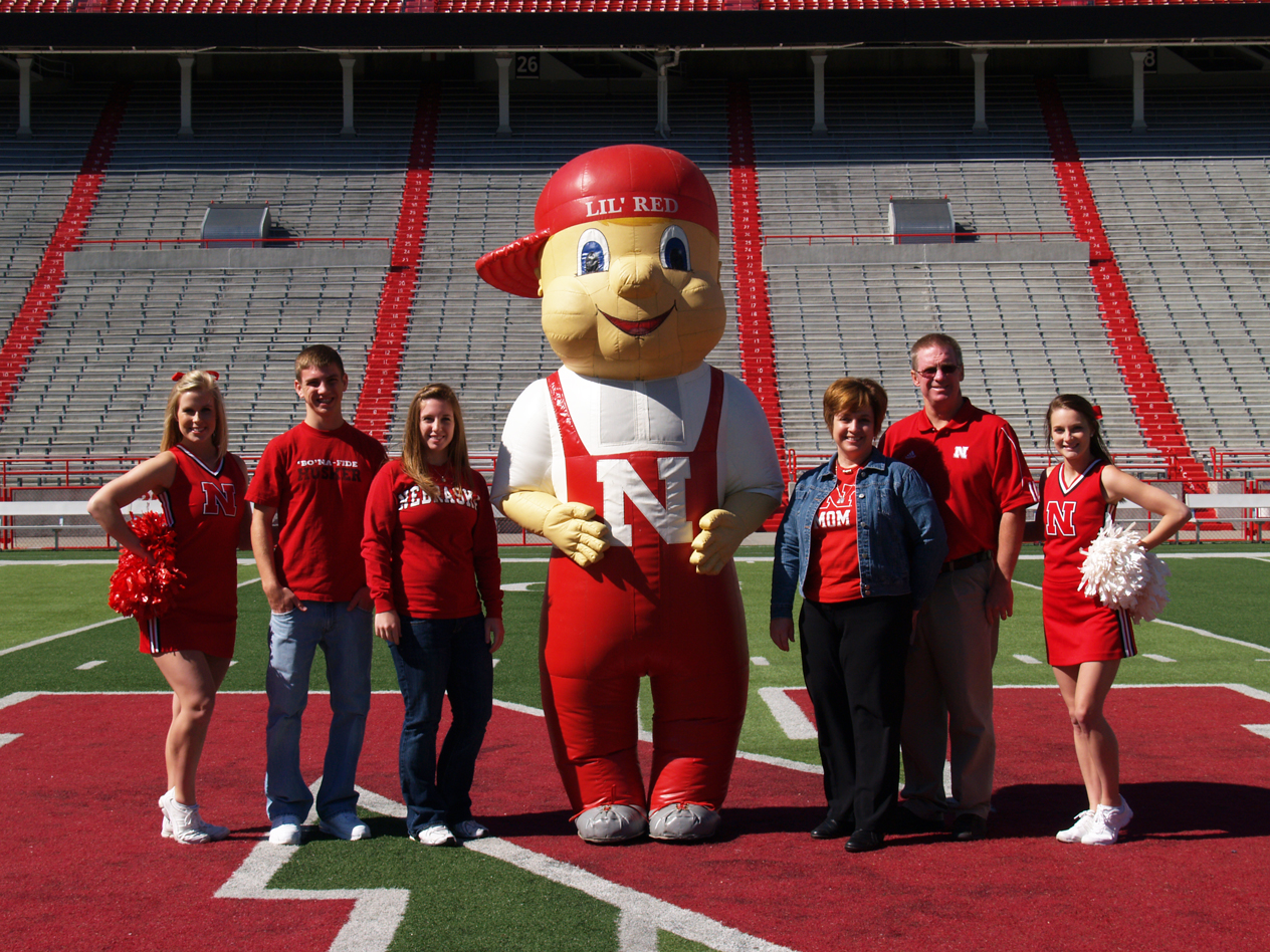 The Berka family strikes a pose with Lil' Red and Husker cheerleaders during their 2010 Parents Week visit.