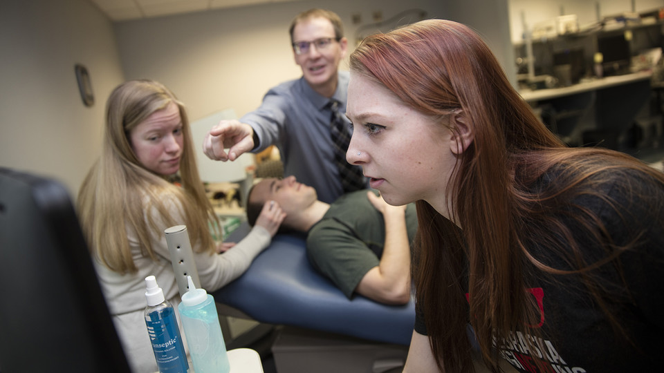 Nebraska students Madison Burger and Allison Porter work with Greg Bashford as part of a UCARE project in 2016. Part of the work, shown here, included using a device that measures brain waves through eyelid pressure. |  Craig Chandler, University Communic