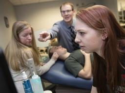 Nebraska students Madison Burger and Allison Porter work with Greg Bashford as part of a UCARE project in 2016. Part of the work, shown here, included using a device that measures brain waves through eyelid pressure. |  Craig Chandler, University Communic