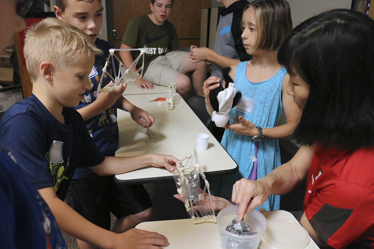 Youth built bridges with straws and tape, then tested how much weight the bridges could hold until they collapsed in the “Amazing Engineering 1” workshop presented by staff and students from the UNL College of Engineering. (Photo by Vicki Jedlicka)