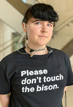 Alyssa Wilson, a security guard at Sheldon, showcases the new "Please don't touch the bison" T-shirts that are being worn by museum staff. The shirts will also be available for free to students during First Friday on Sept. 6.