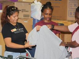 Volunteers assist the local community by sorting clothing at a local thrift shop.