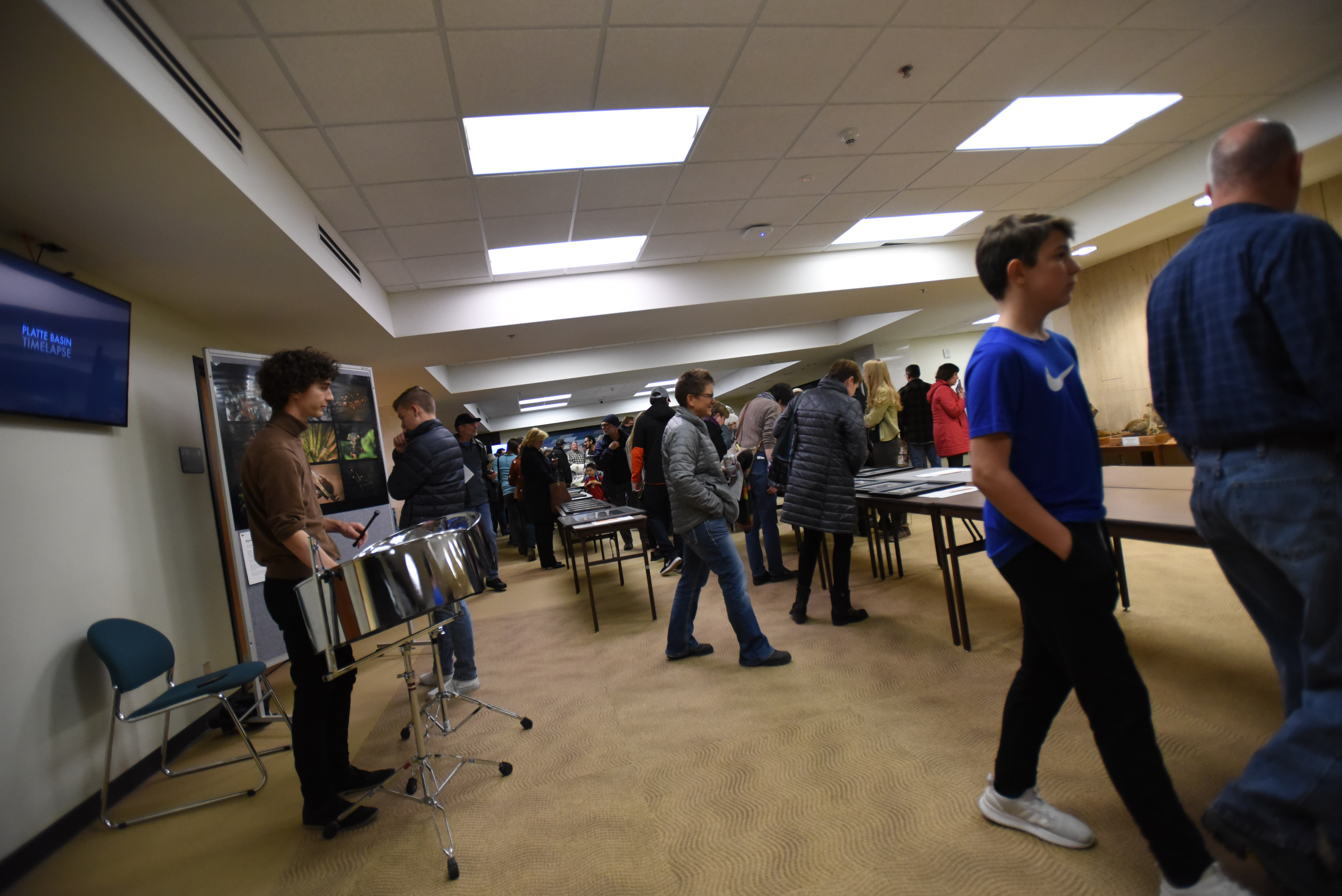 Guests to the Arts for Conservation Night at the School of Natural Resources bid on items Nov. 21, 2019, while listening to Louis Raymond-Kolker play steel drums.