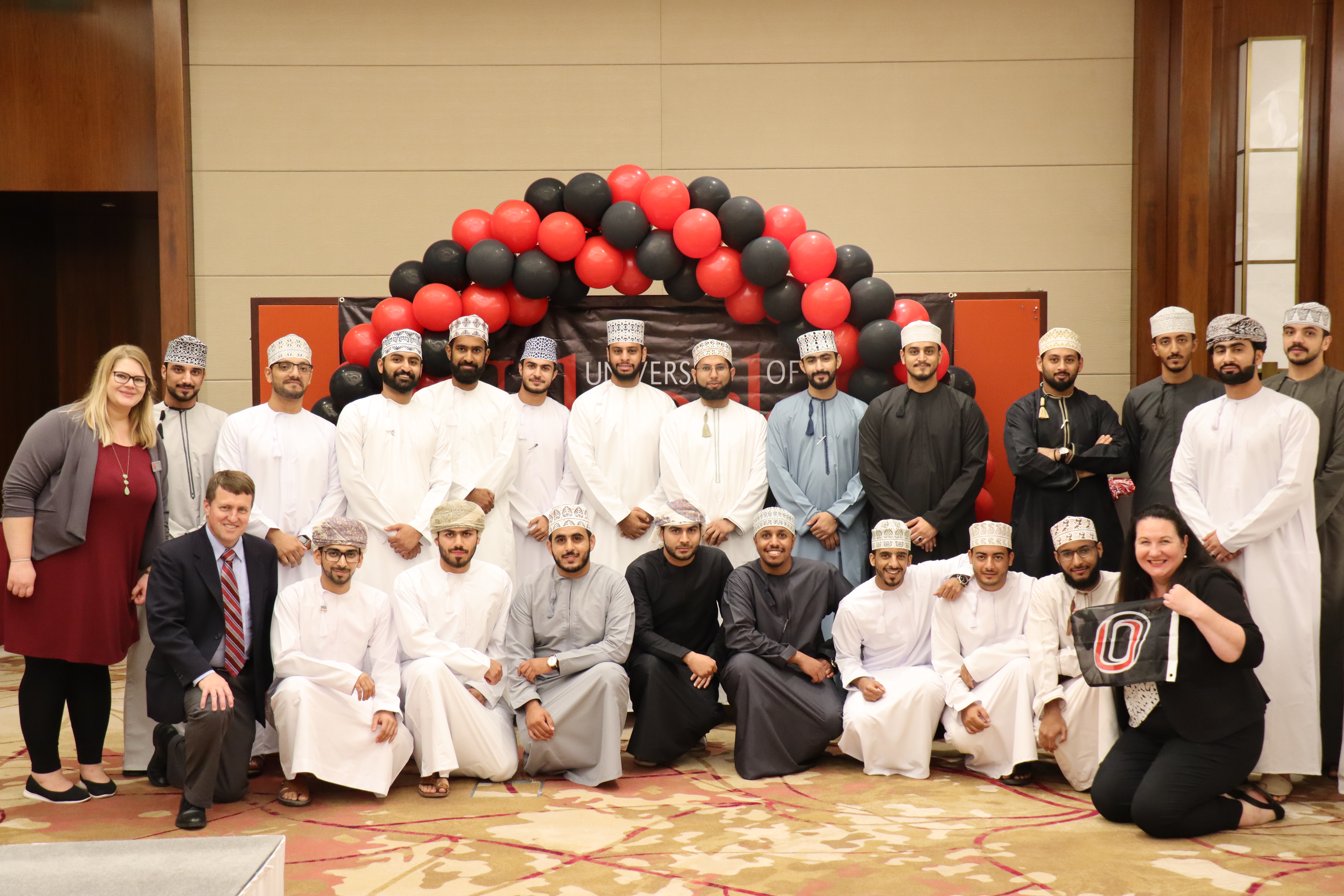 UNL’s Erika Hepburn (top, far left), NU’s Steve Duke (bottom, far left) and UNO’s Asta Reiff (bottom, far right) pose with the male Nebraska alumni at the Omani Alumni Reception on October 26.