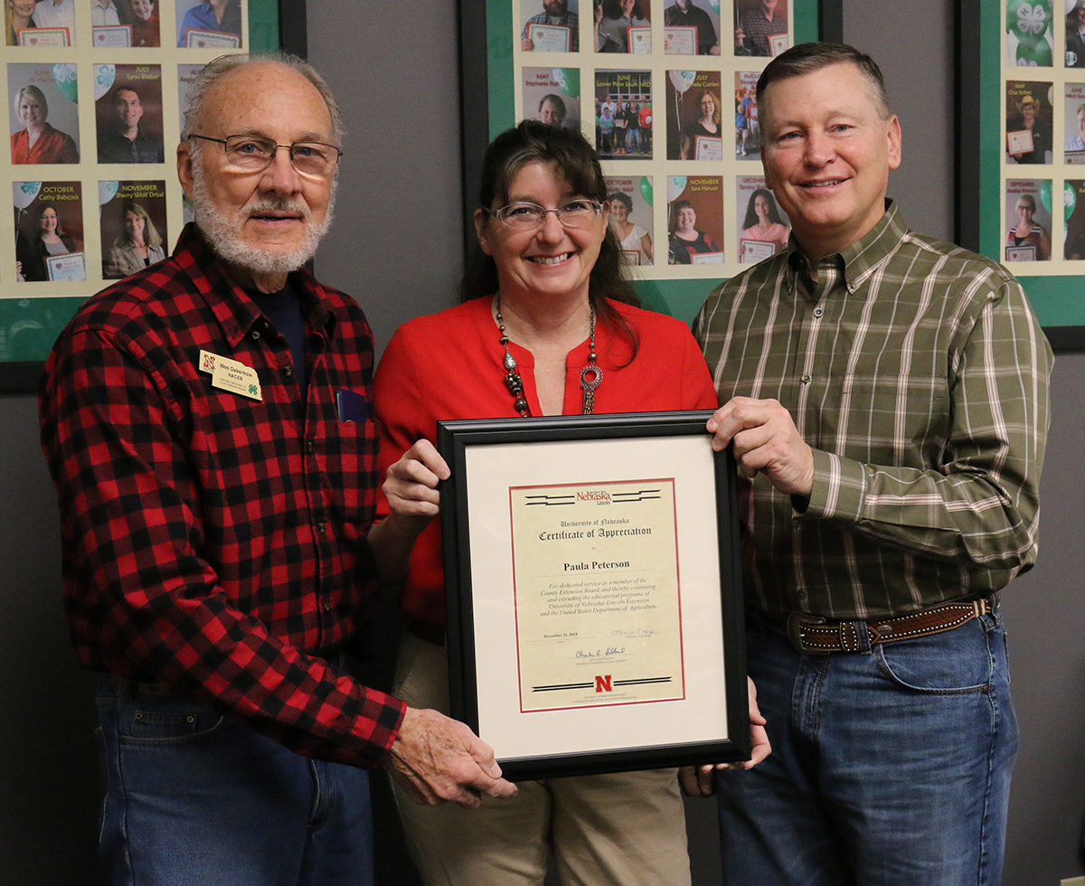 Paula Peterson (center) with Nebraska Association of County Extension Boards Metro District representative Wes Daberkow (left) and Extension Board Vice President Chris Scow (right). Not pictured is Allen Blezek.