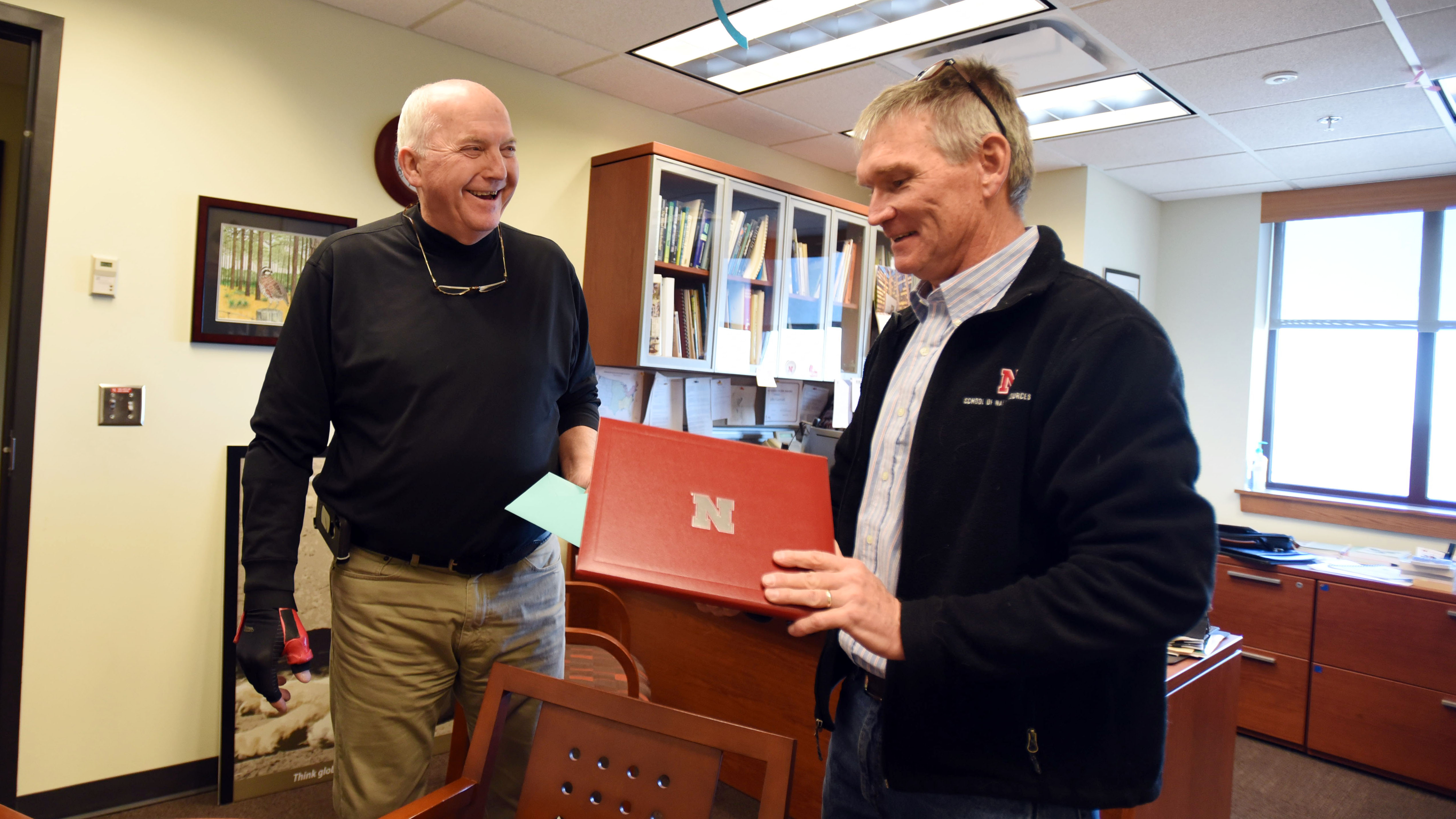 Rick Perk, left, geoscientist with the Center for Advanced Land Management Technologies at the School of Natural Resources, retired Dec. 20, 2019, with a small reception in Hall Hall. Director John Carroll hands him a memento marking the occasion. 