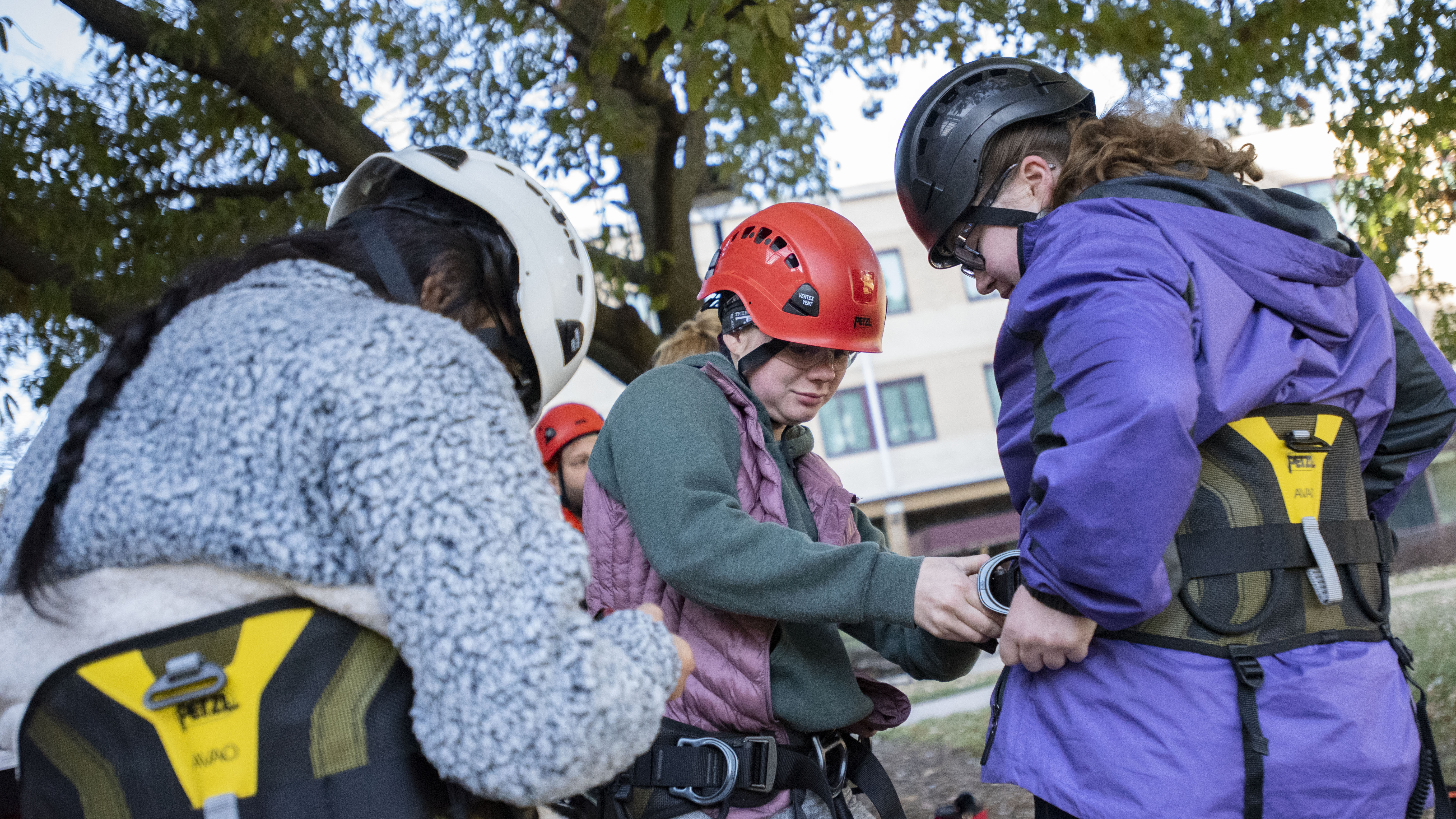 Alaina Kapla, UNL Forestry Club president, helps high school students get on their tree climbing gear during a summer climbing session at Hardin Hall. | Shawna Richter-Ryerson