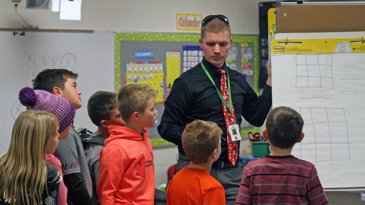 After working on their own, students come together with teacher Andrew Boone to discuss different strategies they used on the MagicSquare problem. Photo by Rachel George, Bellevue Leader
