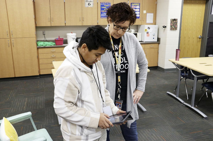 A sixth-grader shows his robot's programming to teacher Patti Maguire at Lexington Middle School. Photo credit: Brian Neben