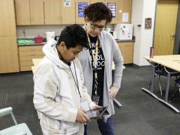 A sixth-grader shows his robot's programming to teacher Patti Maguire at Lexington Middle School. Photo credit: Brian Neben