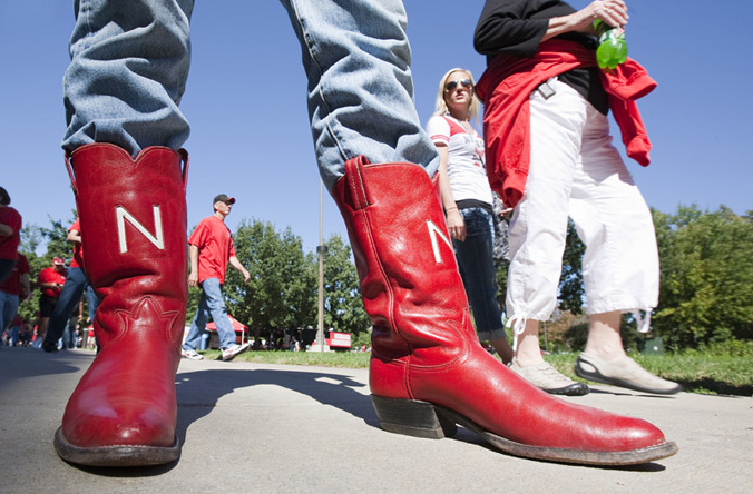 Russell Headlee, a senior from Lincoln, shows off a shiny red pair of boots before the Huskers’ season opener with Western Kentucky University. Headlee said he bought the boots on Ebay last winter. Photo by Craig Chandler, University Communications