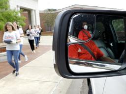 Vijay Patel, reflected in his truck’s side mirror, waits for teachers to deliver iPads for his two children during a curbside pickup at Eastside Elementary, in Clinton, Miss. —Julio Cortez/AP