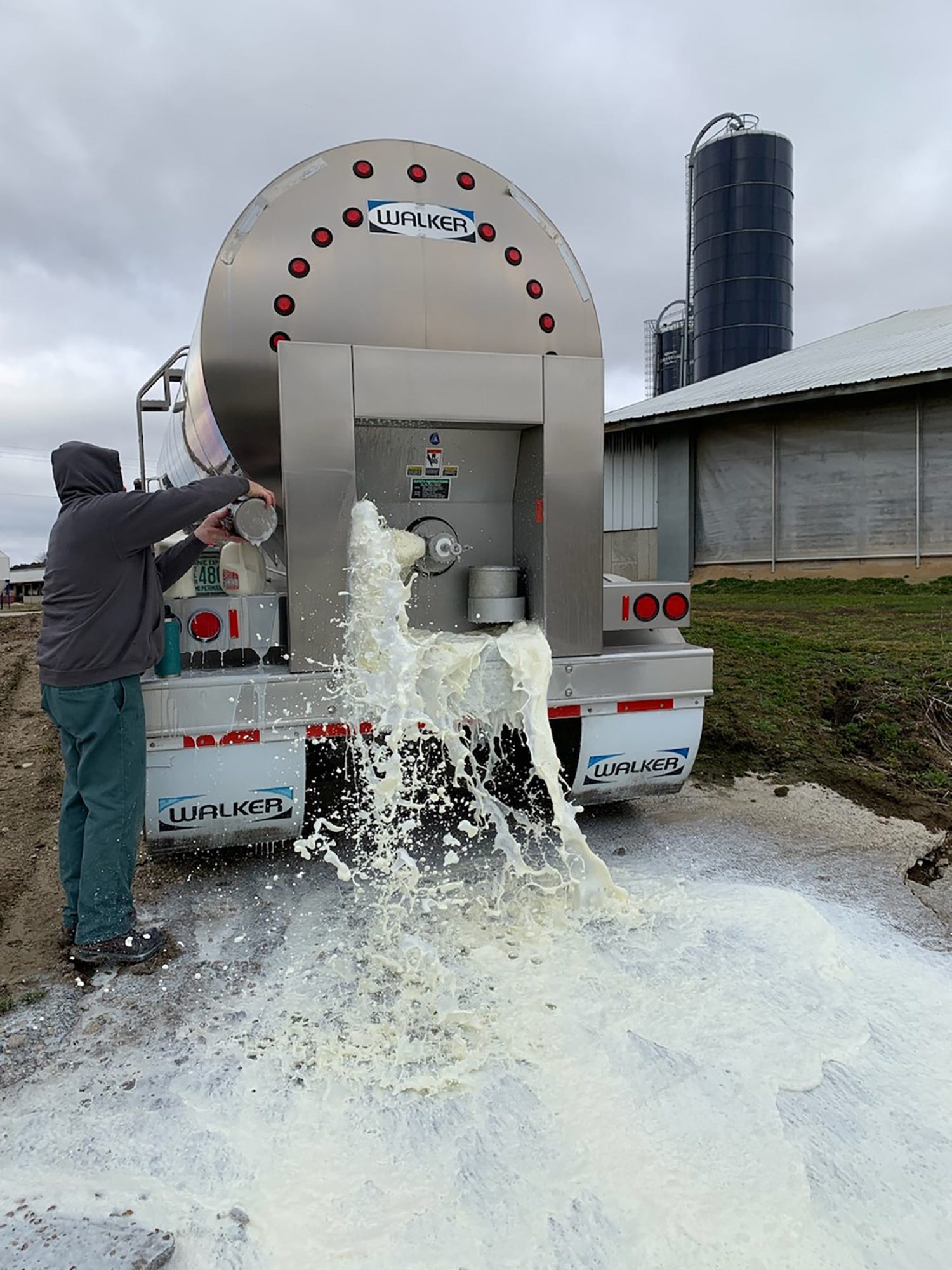 Truck dumping milk onto ground. ©USA Today
