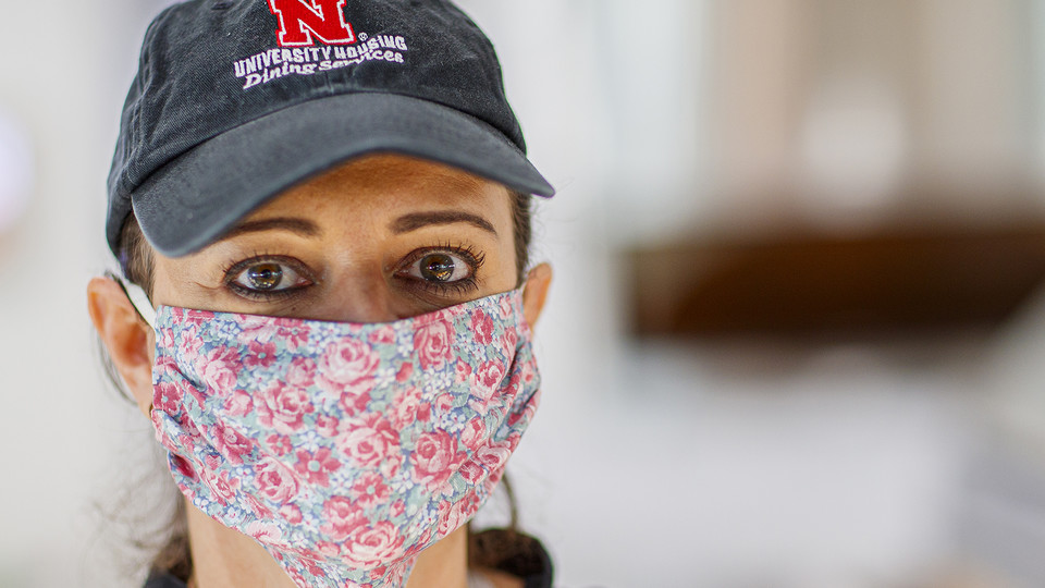 Simone Bilha, a dining service team leader in the Willa Cather Dining Center, wears a homemade cloth mask as she works on April 7. The university is seeking the donation of more than 1,100 homemade masks for essential employees. The masks will help increa