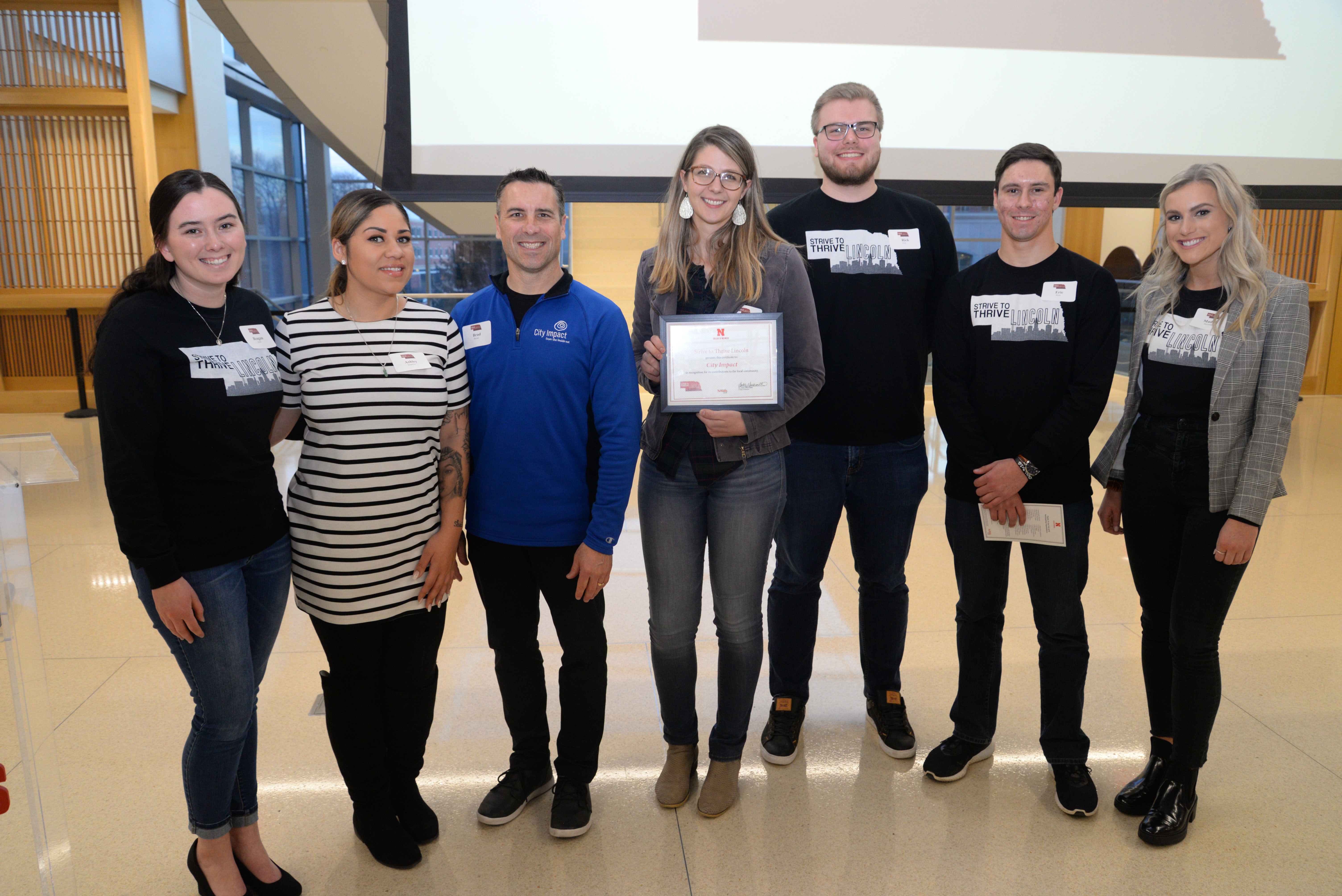 Representatives of City Impact receive a grant from Strive to Thrive Lincoln students at the Fall 2019 Awards Ceremony.