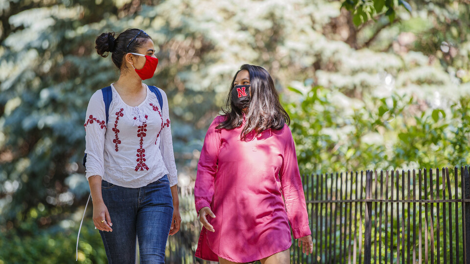 Asmita Jayswal, a junior in computer science (right), and Esha Mishra, a graduate student in physics, wear the new N face mask. More than 60,000 face masks will be distributed to all students, faculty and staff for the fall semester.