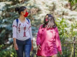 Asmita Jayswal, a junior in computer science (lright), and Esha Mishra, a graduate student in physics, walk along R Street wearing the new N face mask. More than 60,000 face masks will be distributed to all students, faculty and staff for the fall semeste