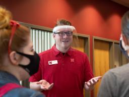 David Strang, an events associate with Academic Services and Enrollment Management, wears a face shield from Nebraska Innovation Campus while visiting with fellow Huskers. The face shields will be distributed to offices and colleges across campus to suppo