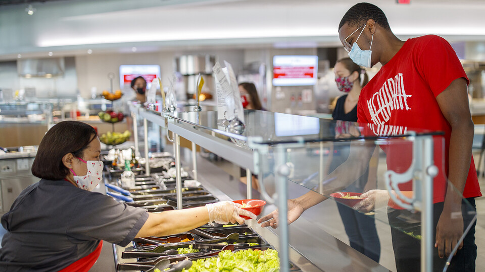 All masked up, students make lunch selections in the Cather Dining Center earlier this summer. In a July 23 email, Chancellor Ronnie Green outlined a number of safety protocols — including the use of facial coverings — that the university community will f