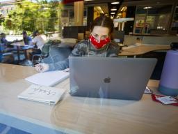 Anna Miles, a freshman from Benson, Arizona, studies from a table with a window view in the Adele Coryell Hall Learning Commons on Aug. 17, the first day of the fall semester.