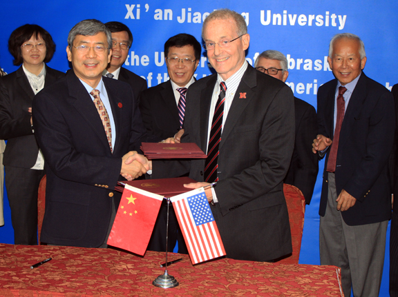 Chancellor Harvey Perlman (front, right) shakes hands with Zheng Nanning, president of Xi'an Jiaotong University, after signing the agreement to create an American Culture Center in China.