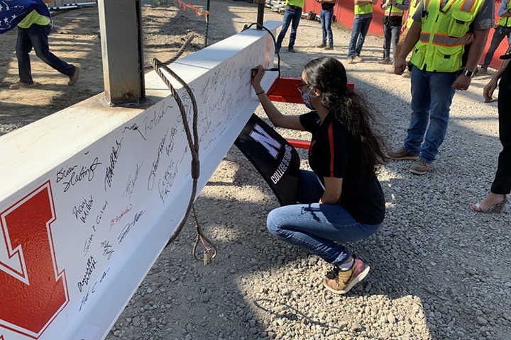 Doctoral student Luz Sotelo signs the final steel beam to be installed in the new Link.