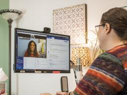 A student talks with a health care provider during a telehealth visit.