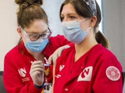 Mary Neill vaccinates Aubrey Busteed at a College of Nursing vaccination clinic on Jan. 29. 