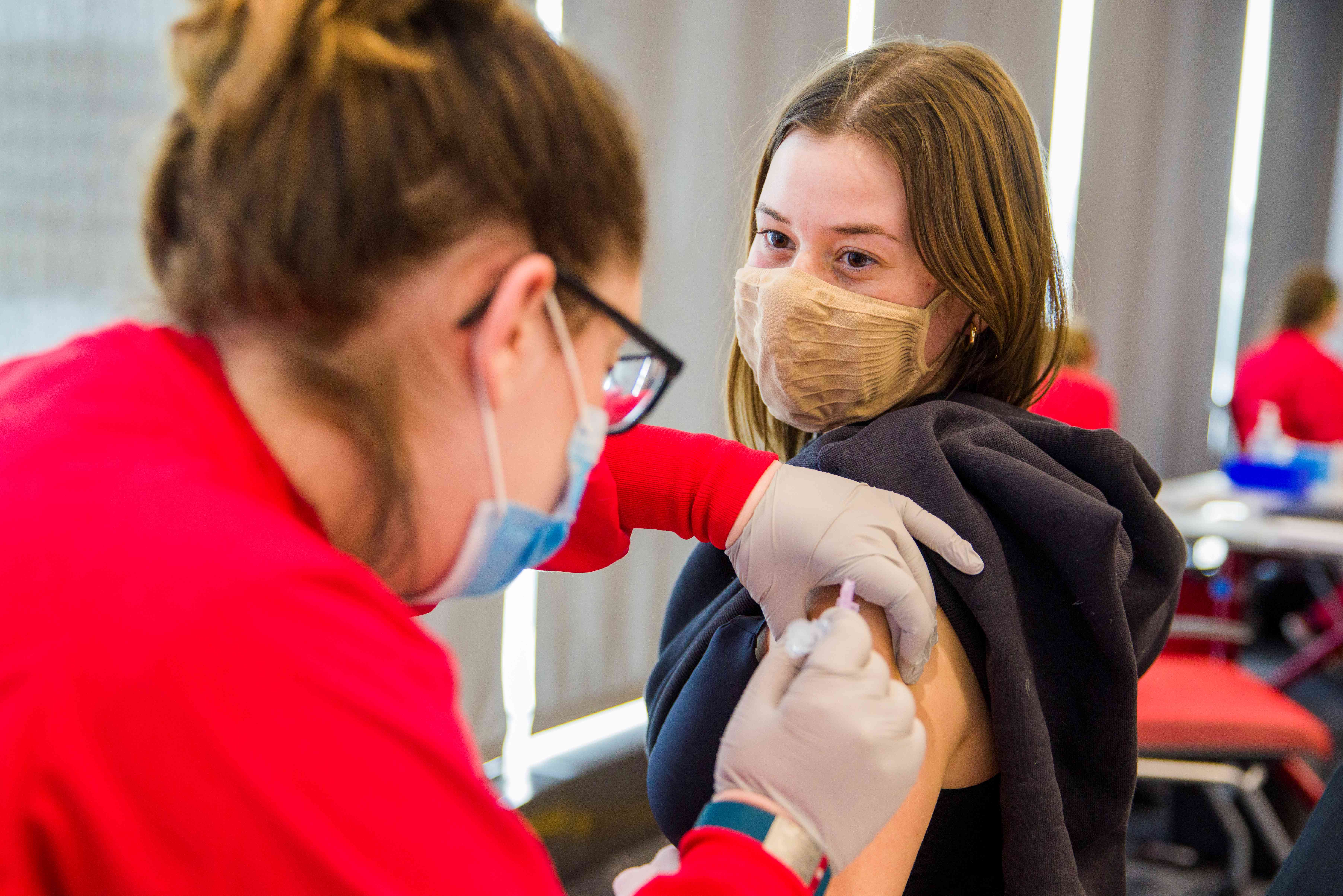 A UNMC student gives a vaccine to a fellow student.