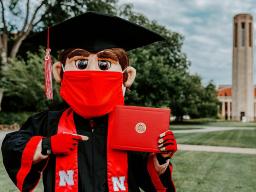 Mascot Herbie Husker with his diploma.