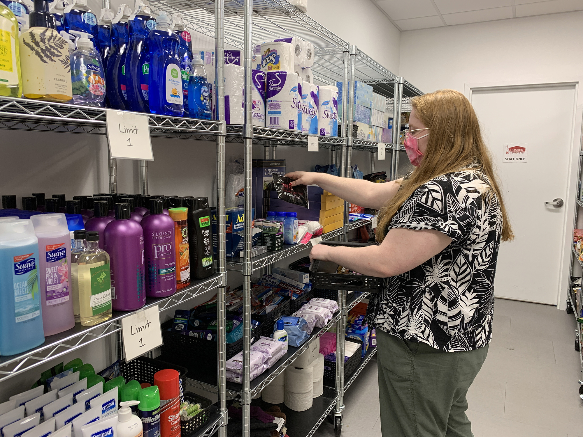 Graduate assistant Katie Peterson restocks the product shelves on the first day that in-person visits resumed at Husker Pantry. May 12, 2021. [Christopher Dulak | Student Affairs]